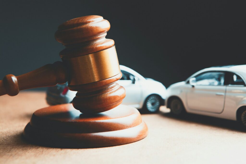 A picture of a gavel and two toy cars