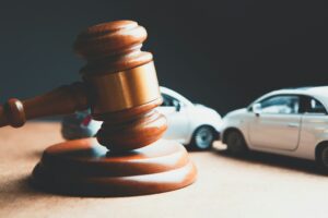 A picture of a gavel and two toy cars