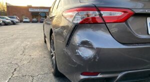 Damaged rear bumper of a car after a rear-end collision in Charlotte showing impact damage and broken taillight